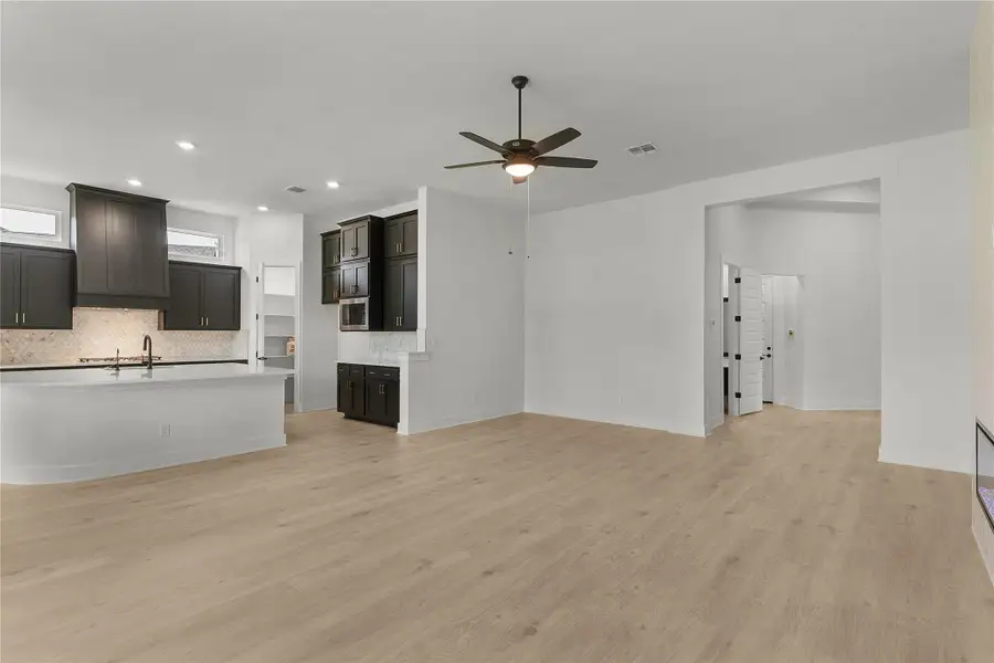 Unfurnished living room with ceiling fan, light wood-style floors, and recessed lighting Unfurnished living room with ceiling fan, light wood-style floors, and recessed lighting