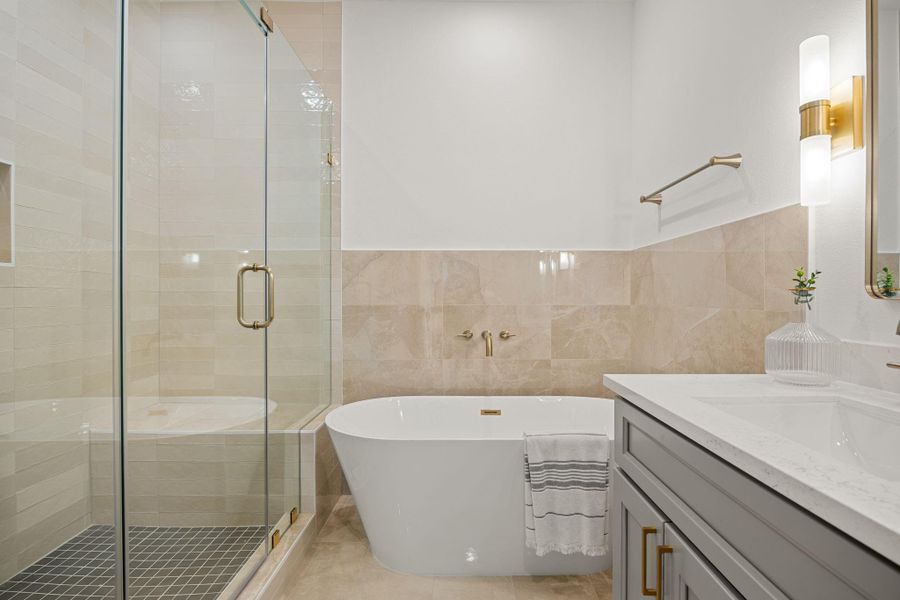 This additional view of the primary bath showcases a walk-in shower with tile surround and a separate garden tub perfect for soaking after a long day. This additional view of the primary bath showcases a walk-in shower with tile surround and a separate garden tub perfect for soaking after a long day.