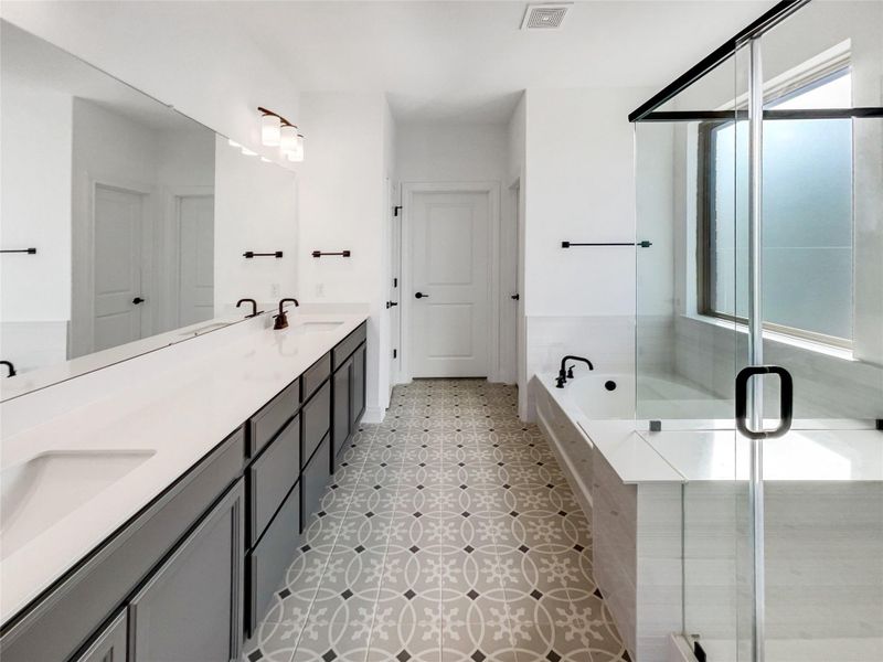 Full bath with visible vents, double vanity, a sink, a shower stall, and a bath