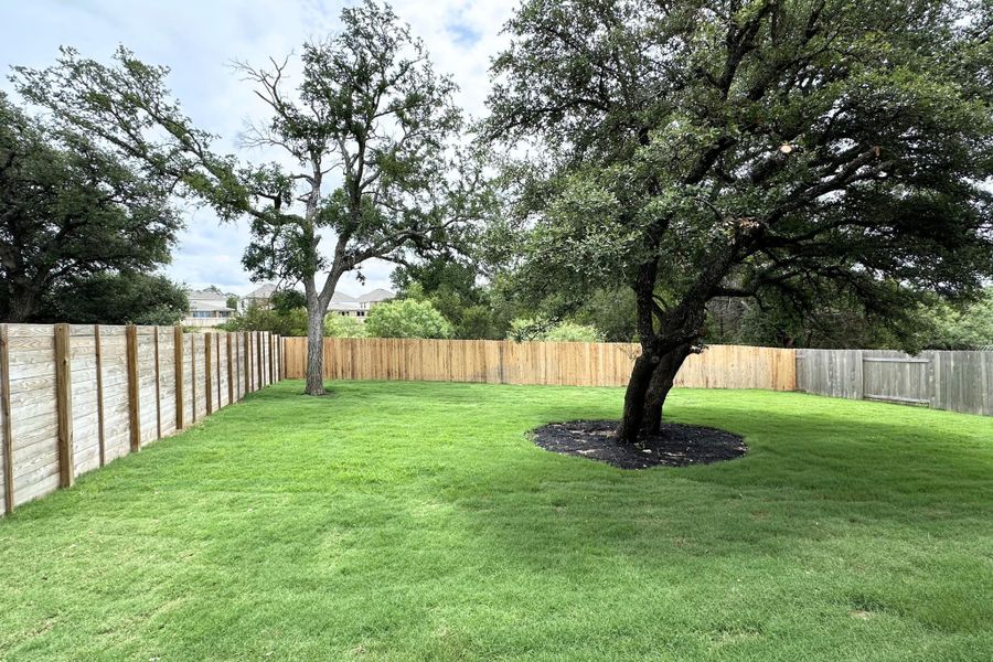 A spacious, verdant yard with mature trees offers a private, serene outdoor retreat.