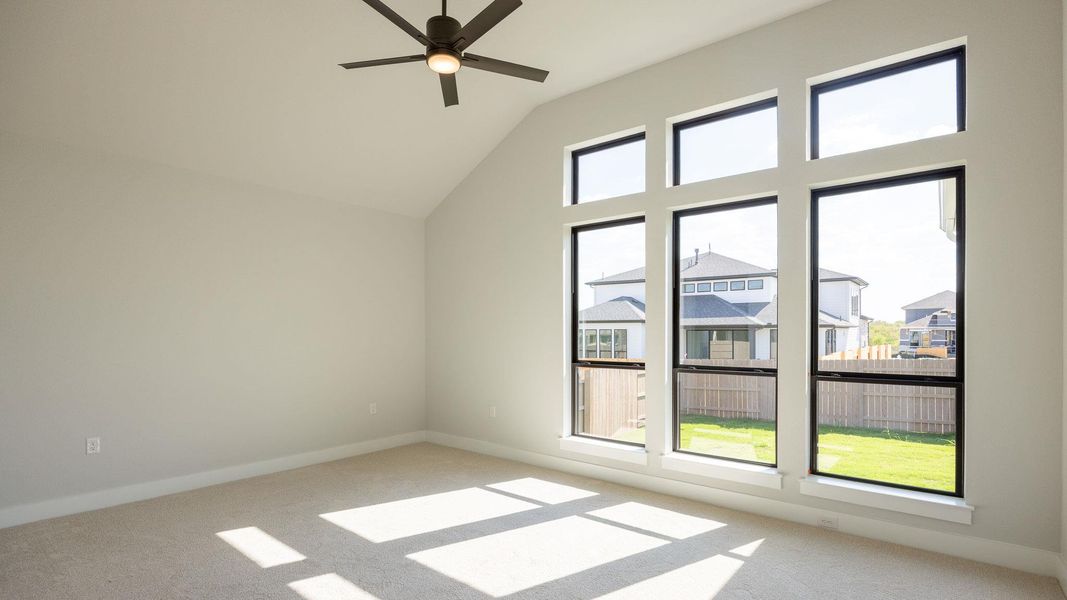 Additional living space with light carpet, ceiling fan, high vaulted ceiling, and a residential view