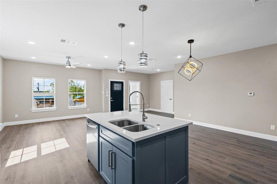 Kitchen with open floor plan, dark wood-type flooring, hanging light fixtures, ceiling fan, and recessed lighting Kitchen with open floor plan, dark wood-type flooring, hanging light fixtures, ceiling fan, and recessed lighting