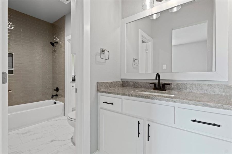 Full bathroom with vanity, toilet, and tiled shower / bath