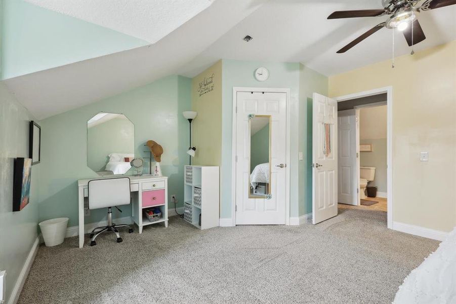 Bedroom featuring lofted ceiling, light carpet, and ceiling fan