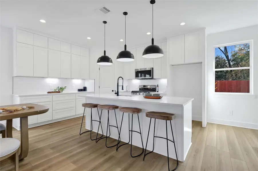 Kitchen and dining area filled with light from large windows.