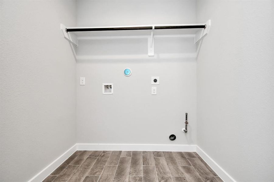 A spacious utility room with ample shelving for organization. It features connections for both gas and electric dryers, making it versatile and functional for all laundry needs. Sample photo of similar plan. Actual colors and selections may vary.