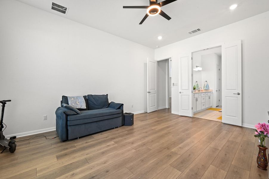 Rich wood floors and recessed lighting anchor this flexible secondary suite with an attached bath.