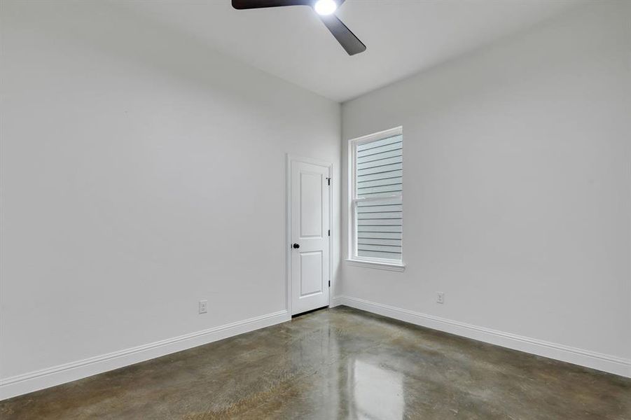 Empty room featuring concrete floors and ceiling fan