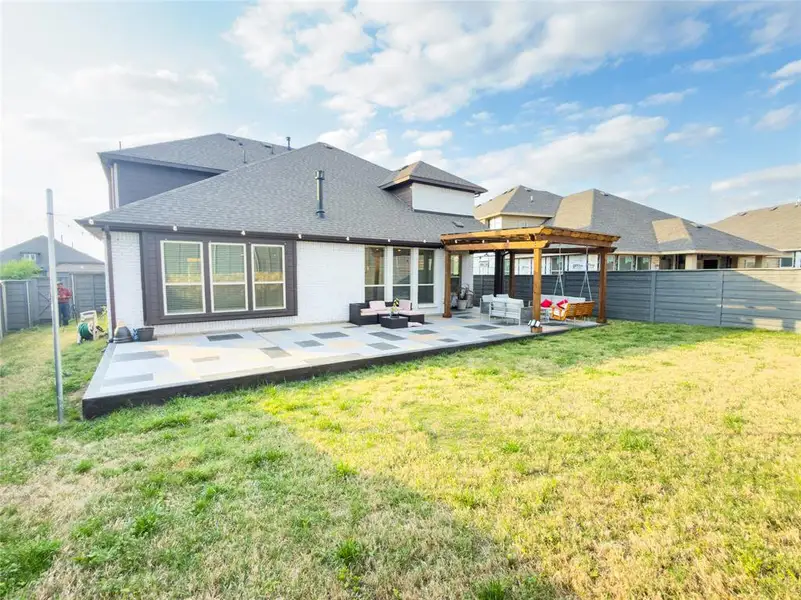 Rear view of house featuring a patio, an outdoor lounge area, a fenced backyard, roof with shingles, and brick siding