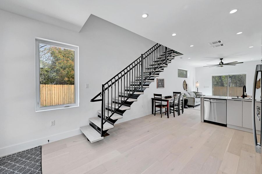 Stairway featuring  a ceiling fan, wood finished floors, recessed lighting