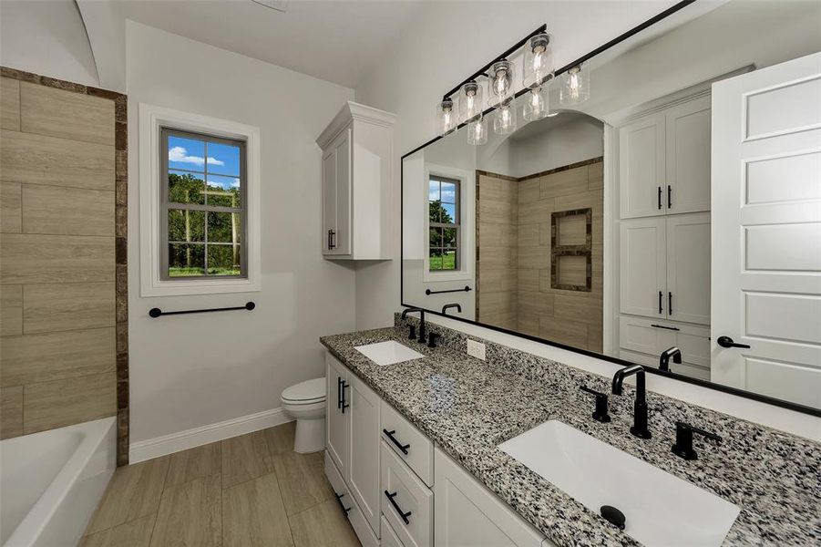 Bathroom with double vanity and baseboards