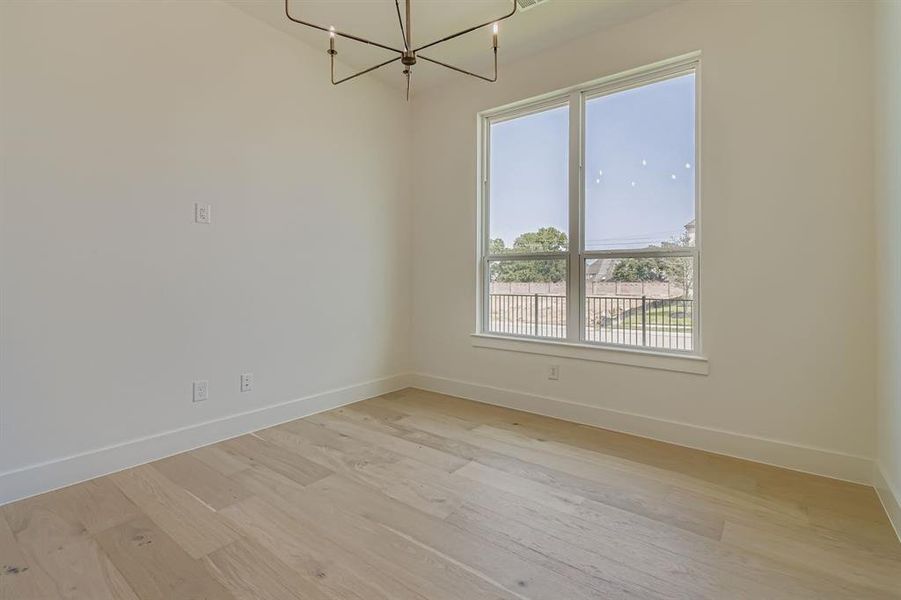 Unfurnished dining area with light wood finished floors and a chandelier Unfurnished dining area with light wood finished floors and a chandelier