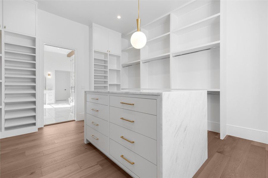 Walk in closet featuring light wood-type flooring Walk in closet featuring light wood-type flooring