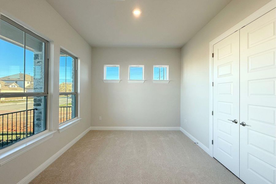 Empty room featuring light colored carpet and baseboards