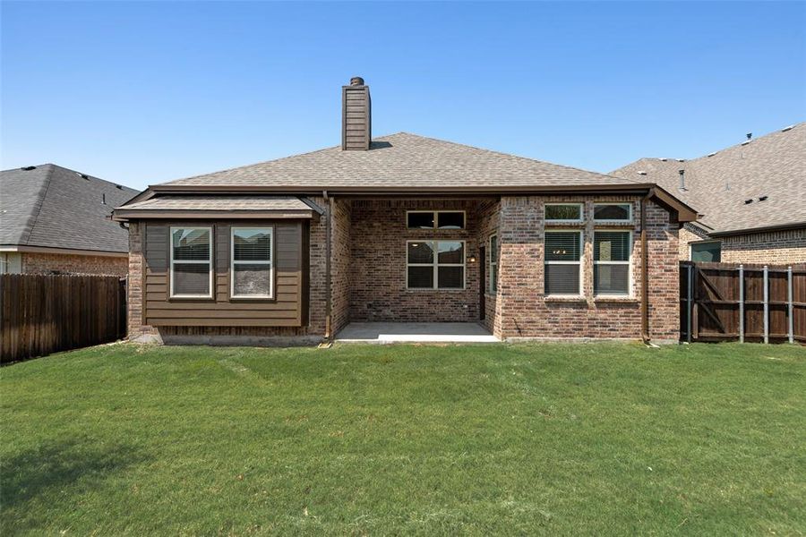 Rear view of house featuring a patio area, a fenced backyard, a chimney, and brick siding Rear view of house featuring a patio area, a fenced backyard, a chimney, and brick siding