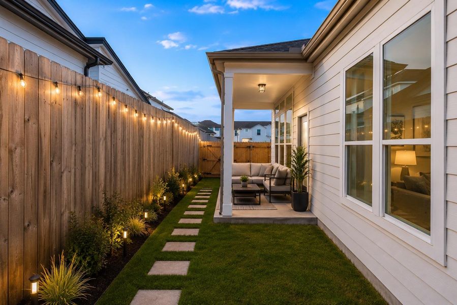 A private backyard oasis features a welcoming covered patio and a charming path leading to a gated side entrance.