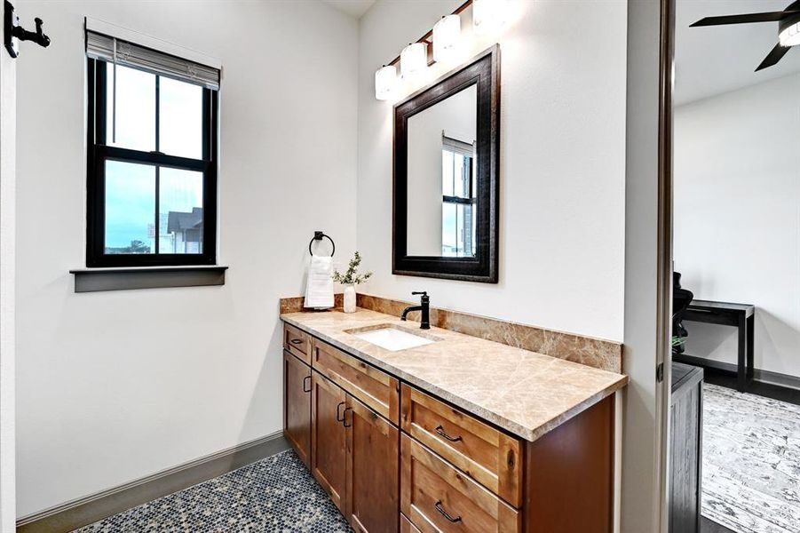 Bathroom featuring vanity, a ceiling fan, and dark tile patterned flooring