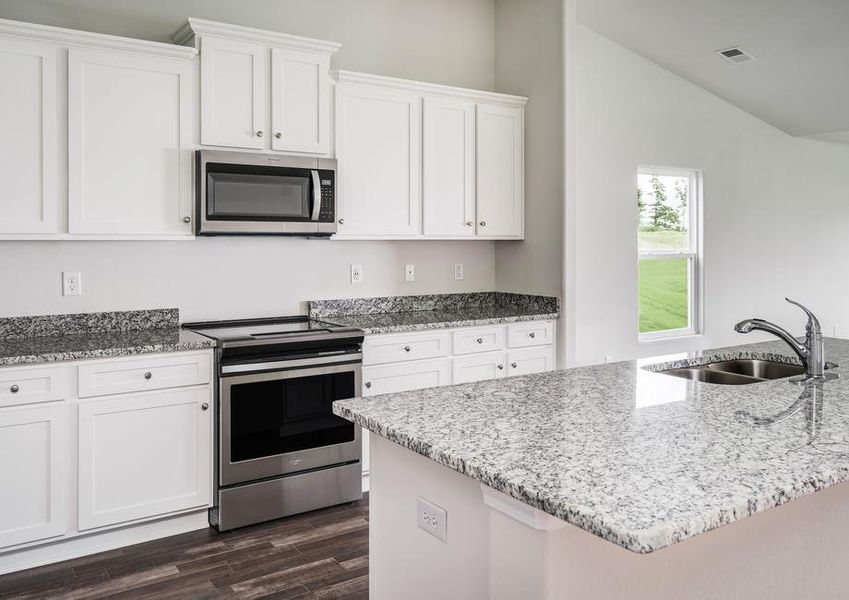 Chef-ready kitchen with granite countertops, white cabinetry with hardware, stainless steel appliances and vinyl flooring.