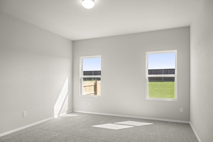 Image of home primary bedroom with light carpet, white walls, and two windows