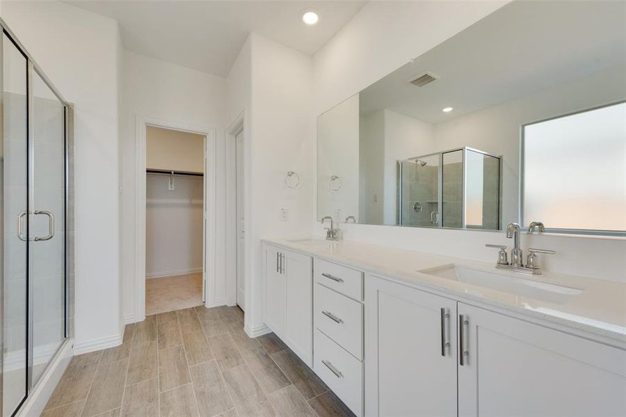 Bathroom featuring double sink vanity and walk in shower