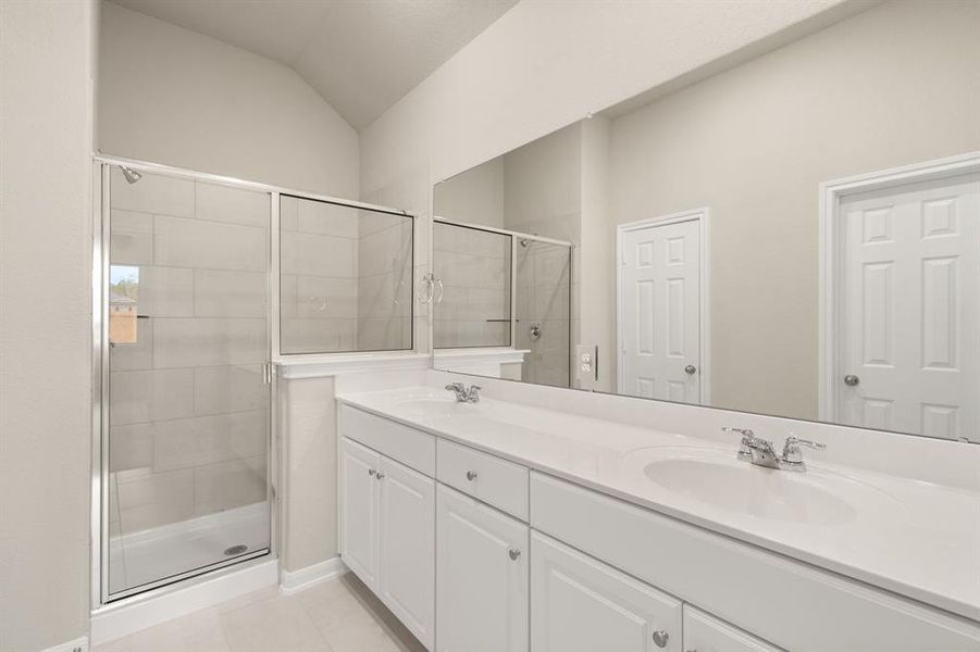 The en-suite bathroom offers a spa-like atmosphere with its elegant design, high end finishes, and tasteful lighting, creating a retreat within your own home.