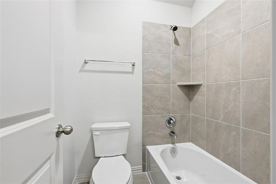 Full bathroom featuring shower combination and toilet Full bathroom featuring shower combination and toilet