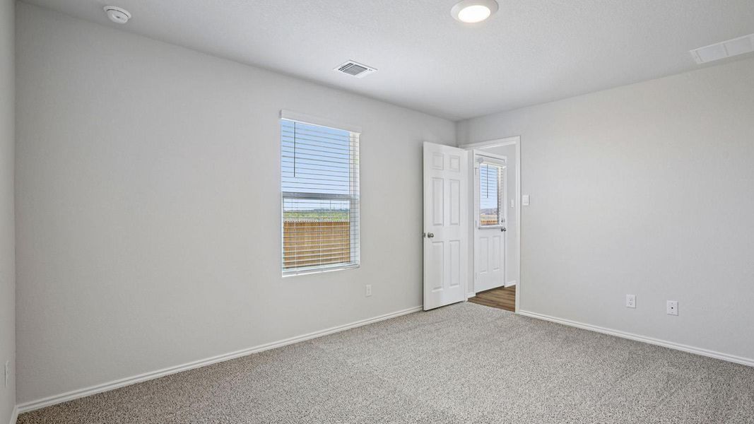 A quiet bedroom with light carpet offers a peaceful retreat.