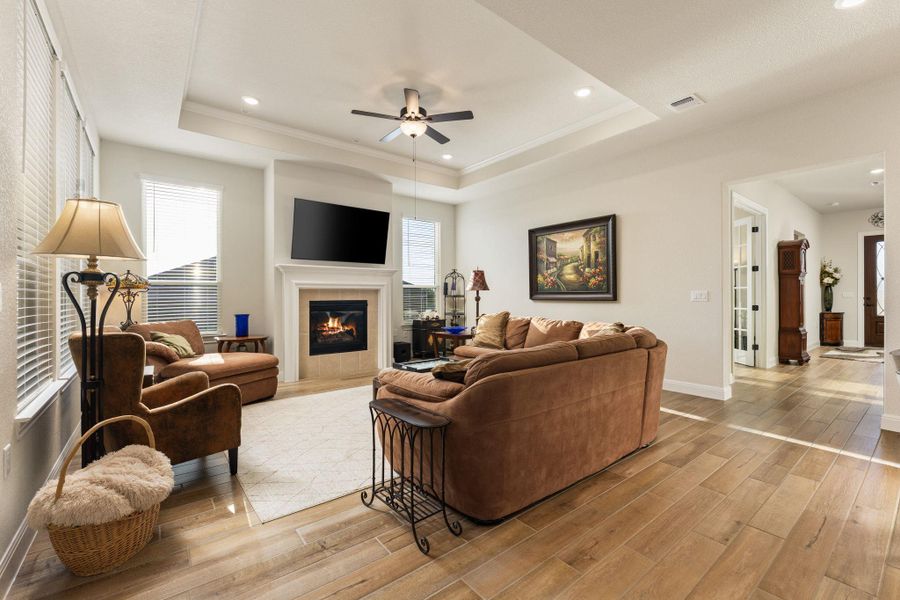 The bright living room features a tray ceiling and is anchored by a fireplace. The bright living room features a tray ceiling and is anchored by a fireplace.
