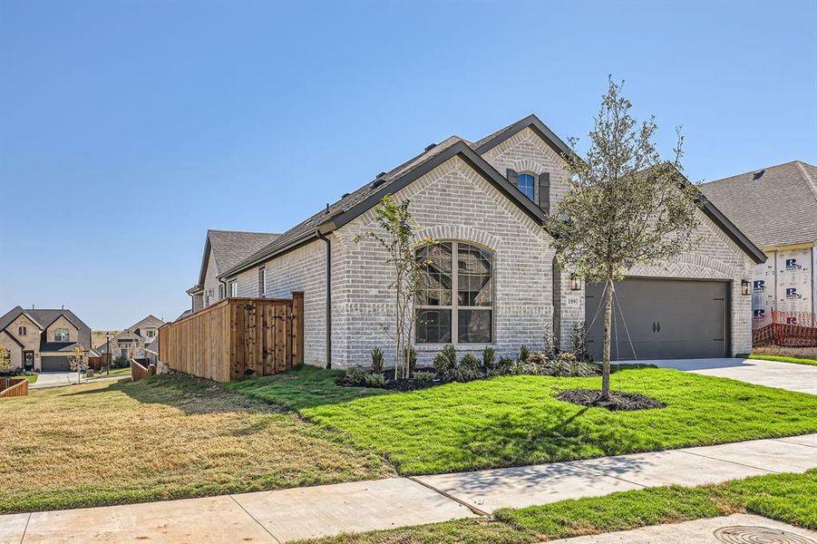 French country home featuring a front yard and a garage