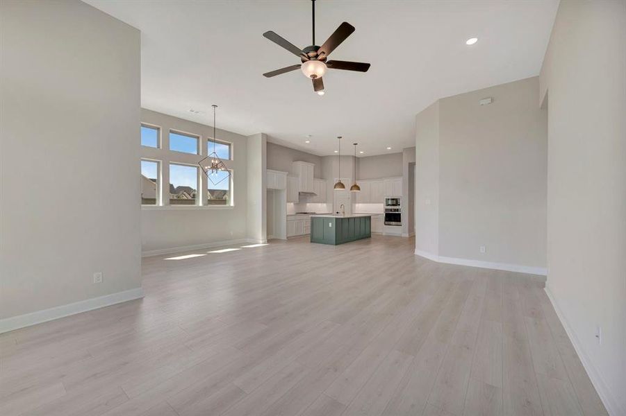 Spacious open-concept interior featuring light wood-finish flooring and neutral wall tones