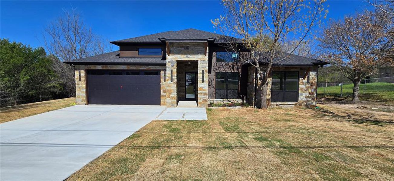 Prairie-style house with stone siding, driveway, a front lawn, and a garage Prairie-style house with stone siding, driveway, a front lawn, and a garage