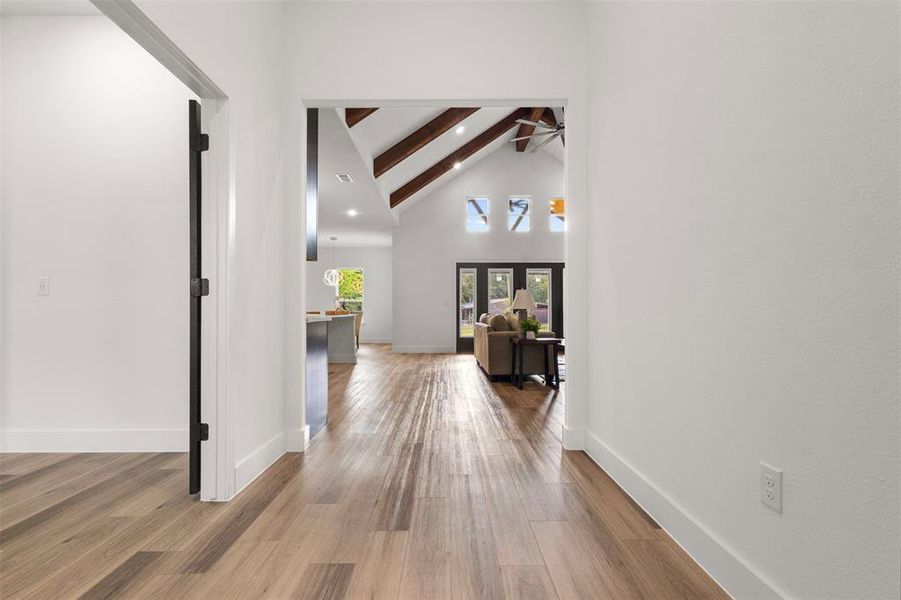 Hall featuring high vaulted ceiling, beamed ceiling, light wood finished floors, and recessed lighting