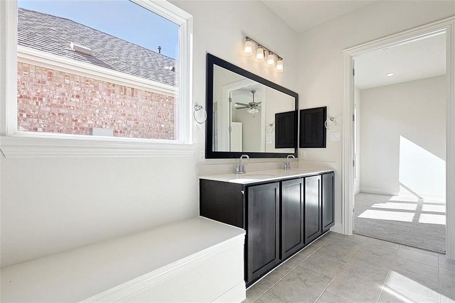 Bathroom with tile patterned floors, vanity, and ceiling fan