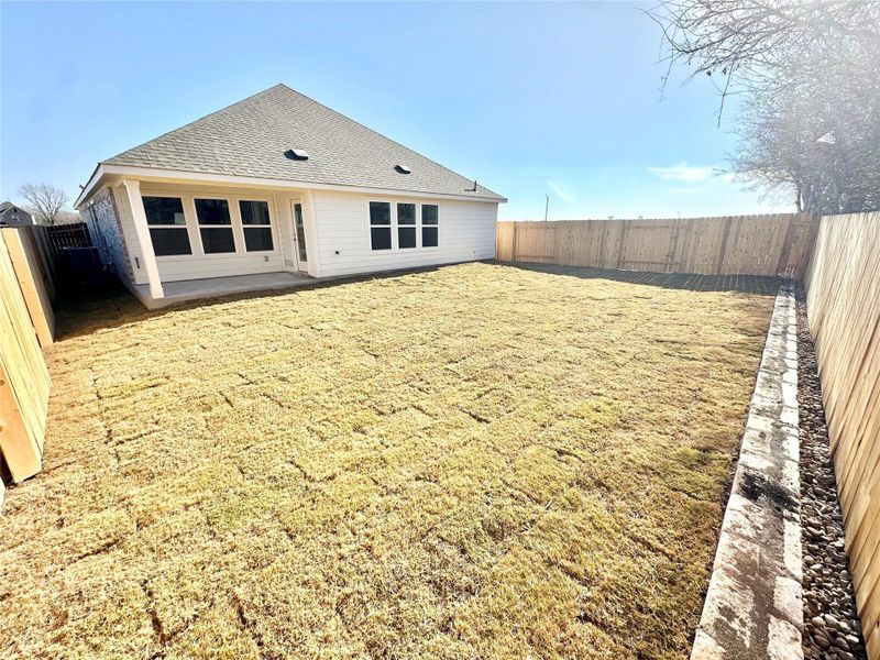 Rear view of property featuring a fenced backyard, a patio, and roof with shingles