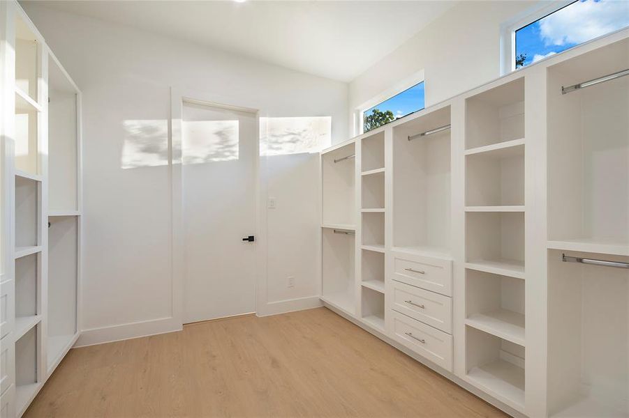 Walk in closet with light wood-style floors