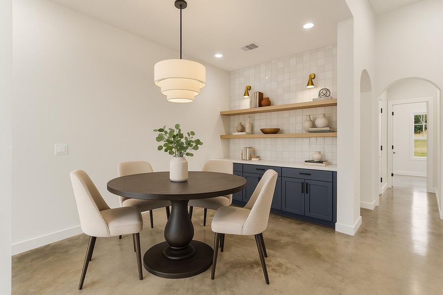 Dining room featuring finished concrete flooring, arched walkways, and recessed lighting Dining room featuring finished concrete flooring, arched walkways, and recessed lighting