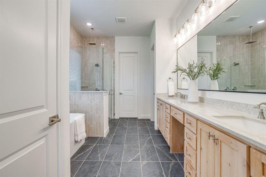 Primary bathroom with a separate shower, double vanity, level 4 Quartz countertops, and a garden tub.