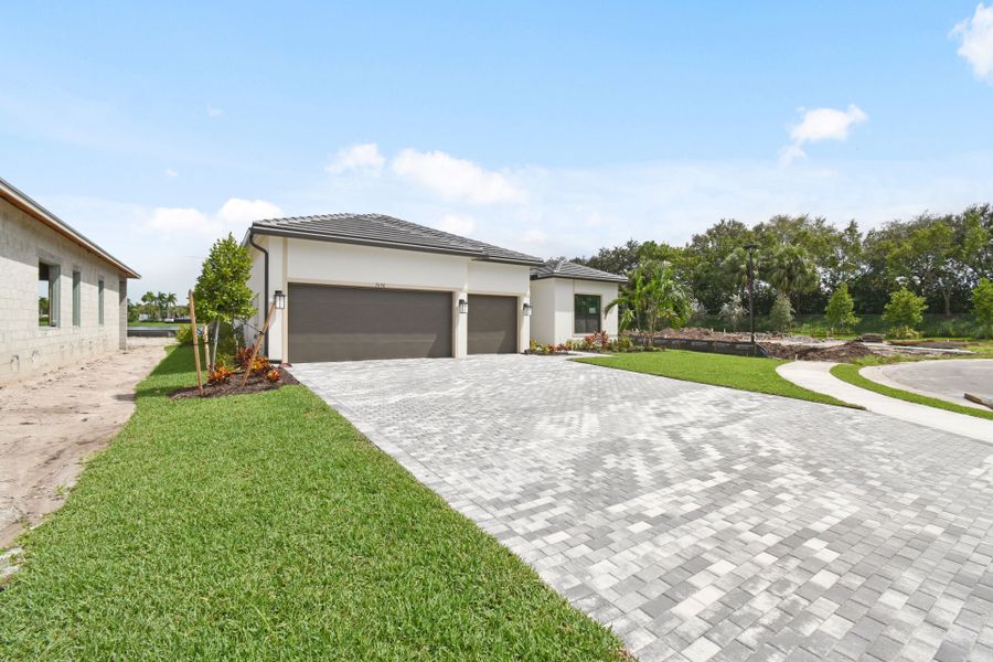 Front exterior of a new home in Greyhawk Landing, Lake Worth, FL, highlighting curb appeal (Image 21).