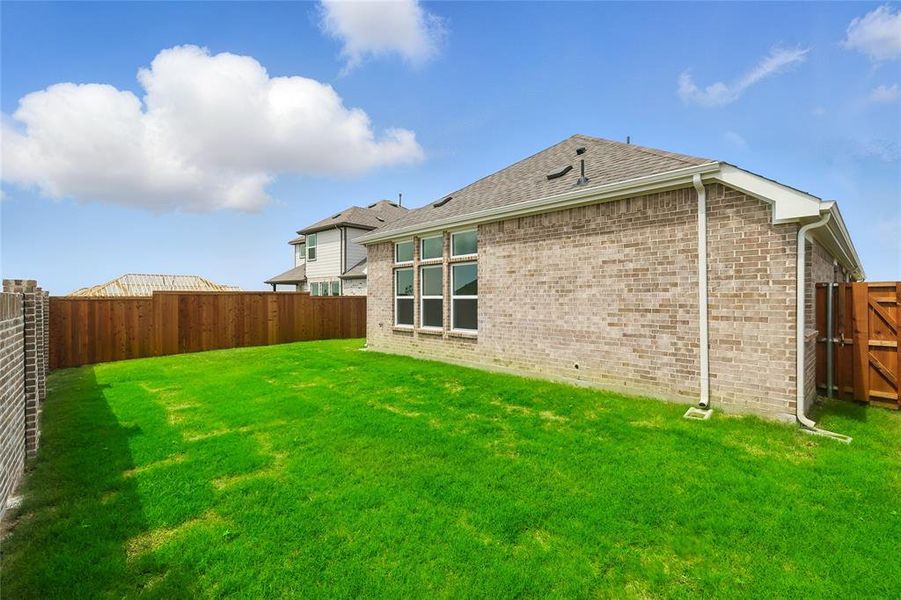 Back of house with brick siding and roof with shingles
