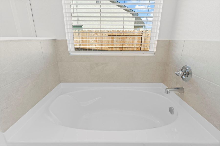 Enjoy a relaxing soak in this inviting tub surrounded by clean tile finishes and a large window that brings in natural light. A perfect spot to unwind and recharge!  Bubble me away!