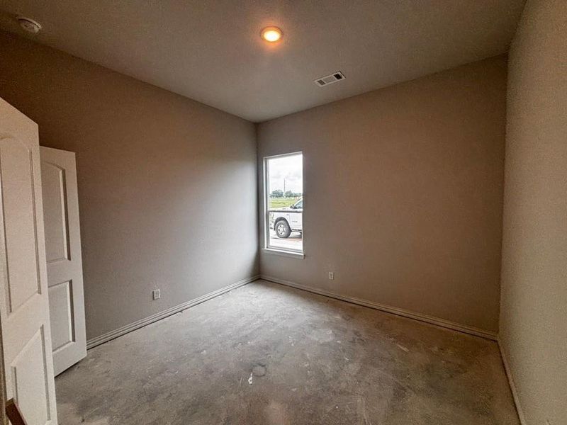 Neutral-toned room featuring a single window, recessed ceiling lighting, and a smoke detector