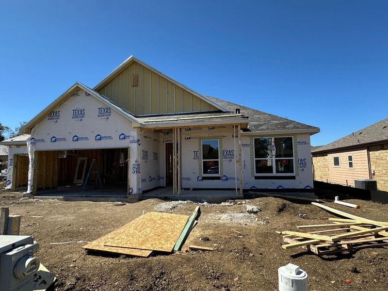 Property under construction featuring a garage, a patio area, and board and batten siding