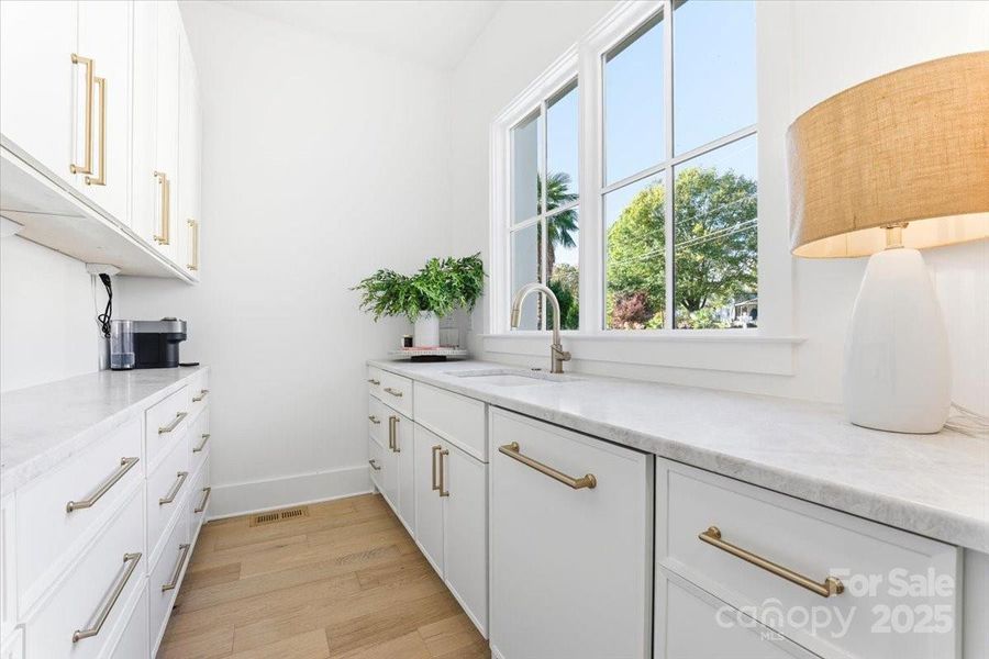 Scullery/Pantry with dishwasher, sink, ample storage for small appliances and cabinetry, quartzite countertops, and lots of windows for bright natural light. Scullery/Pantry with dishwasher, sink, ample storage for small appliances and cabinetry, quartzite countertops, and lots of windows for bright natural light.