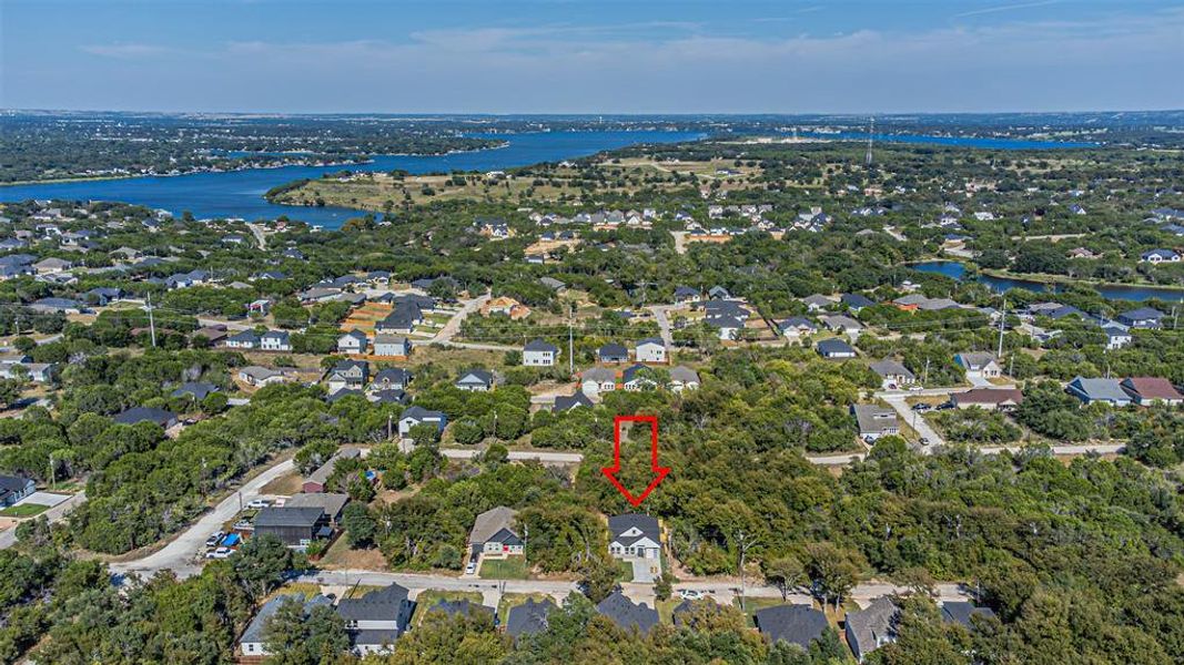 Aerial view of property and surrounding area with nearby suburban area and a nearby body of water