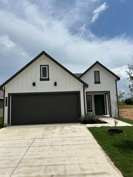 Front exterior of a new home in Cornerstone, Rockdale, TX, highlighting curb appeal (Image 1).