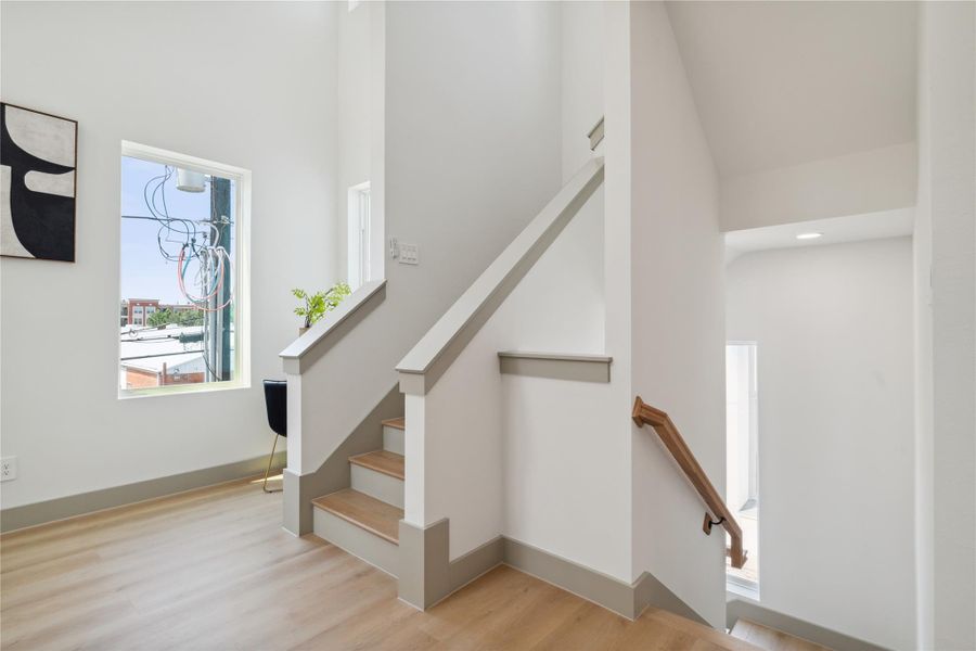 Elevated baseboards and soft neutral hues add depth and dimension to this light-filled vertical connection.