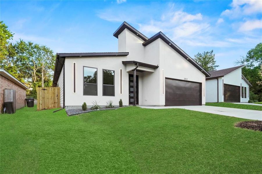 Contemporary house featuring stucco siding, concrete driveway, and an attached garage Contemporary house featuring stucco siding, concrete driveway, and an attached garage