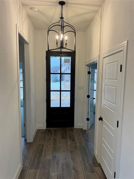 Doorway to outside featuring a notable chandelier