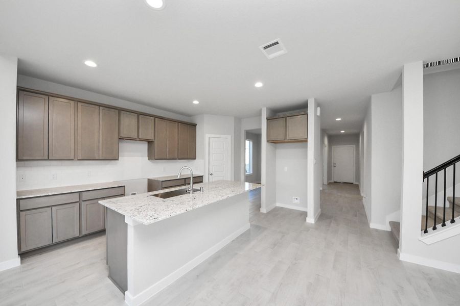 The open concept effortlessly connects the kitchen to the expansive family room, forming a perfect hub for gatherings. This seamless flow creates an inviting space where cooking and socializing come together harmoniously. Sample photo of completed home with similar floor plan. Actual colors and selections may vary.