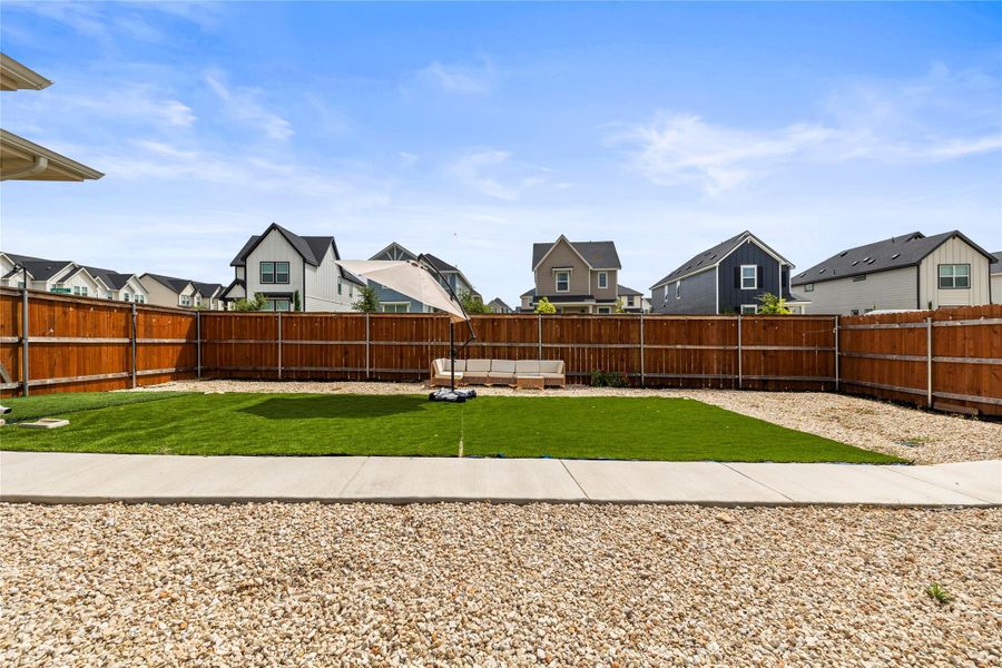 A lawn like turf newly installed gives you nearly maintenance free living, plus the gravel path define this private yard, enclosed by a privacy wooden fence.